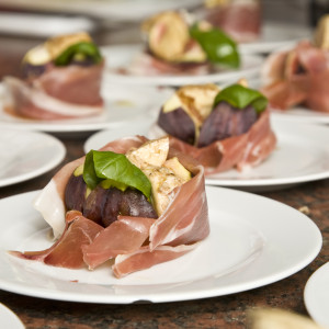 Feigen und Parmaschinken sind kunstvoll auf Tellern drapiert.